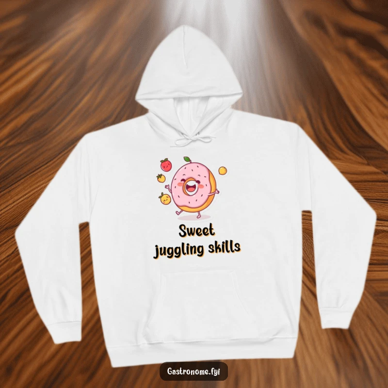 Funny donut character hoodie cheerfully juggling three small fruits, offering cozy comfort and a splash of playful humor.