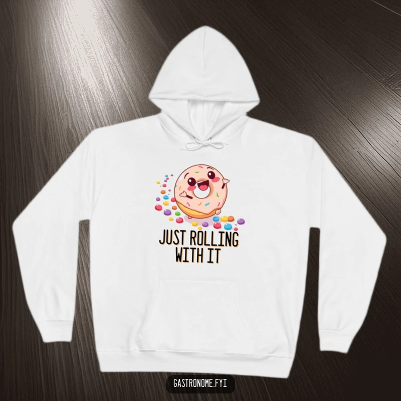 Funny hoodie depicting a joyful donut character rolling downhill, leaving a trail of colorful candies, for cozy and sweet enjoyment.